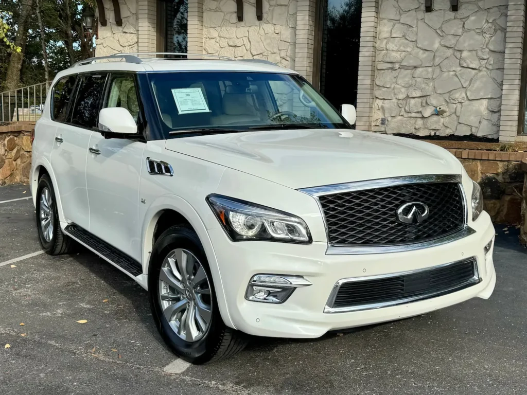 White 2017 Infiniti QX80 parked outside a stone-clad building.