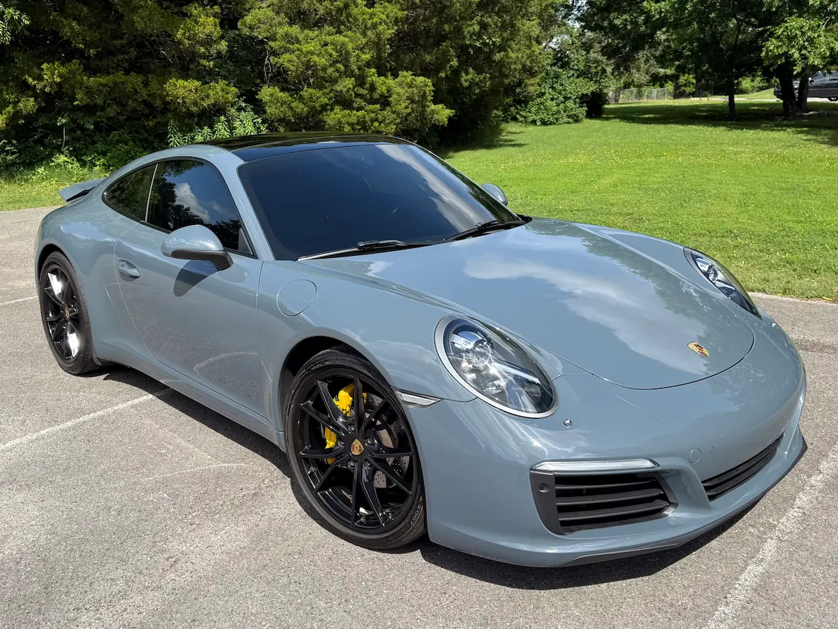 Blue-gray 2017 Porsche 911 Carrera with black wheels and yellow brake calipers