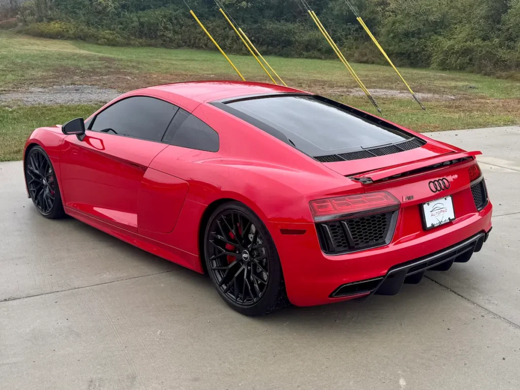 2018 Audi R8 V10 in red viewed from the rear showcasing taillights, diffuser, and side blades.