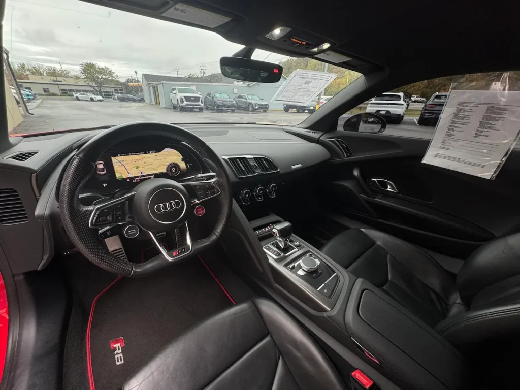 Interior of 2018 Audi R8 showing flat-bottom steering wheel, digital cockpit, and premium sport seats.