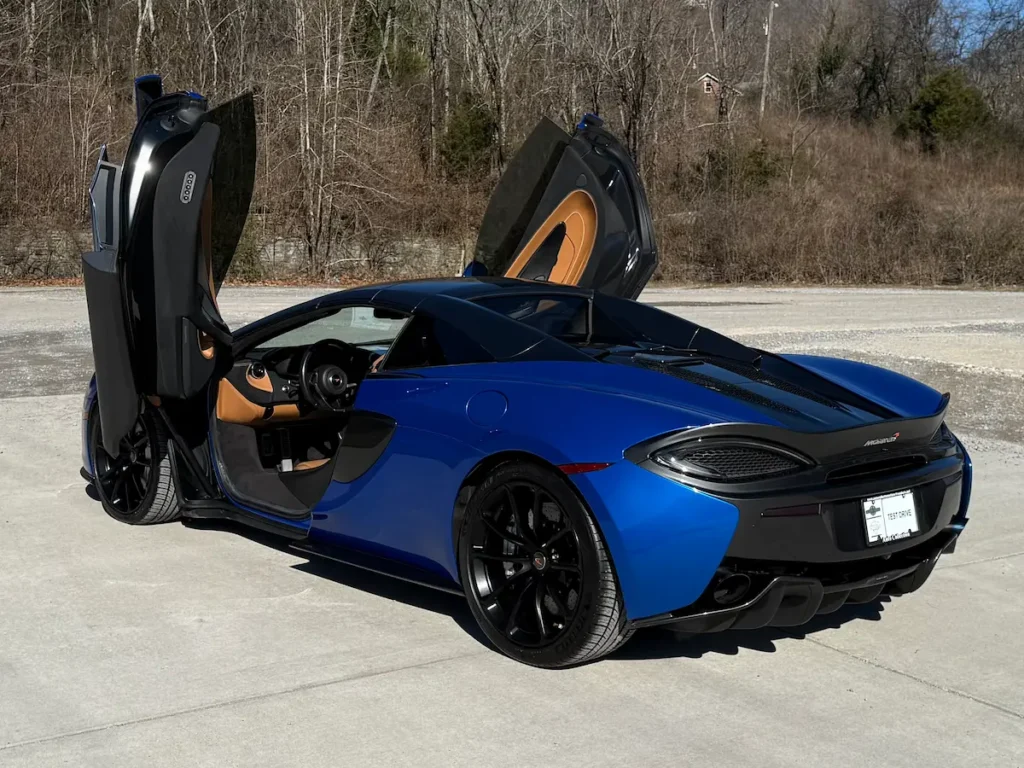 Rear exterior view of a blue 2018 McLaren 570S Spider