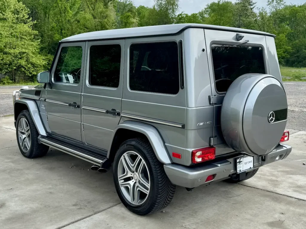 2018 Mercedes-Benz G63 AMG rear three-quarter view in silver with side exhaust