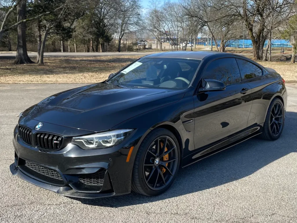 Front three-quarter view of a 2019 BMW M4 CS in black showcasing its aerodynamic design and signature M styling.