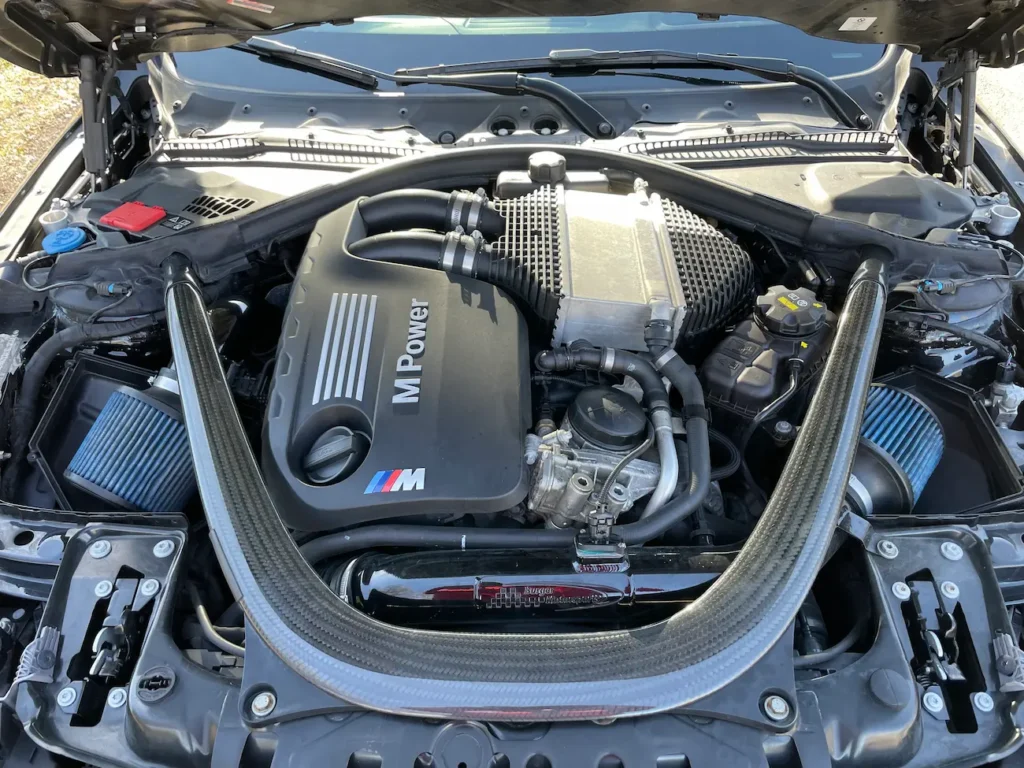 Engine bay of the 2019 BMW M4 CS with M Power twin-turbo inline-six engine and carbon strut brace.