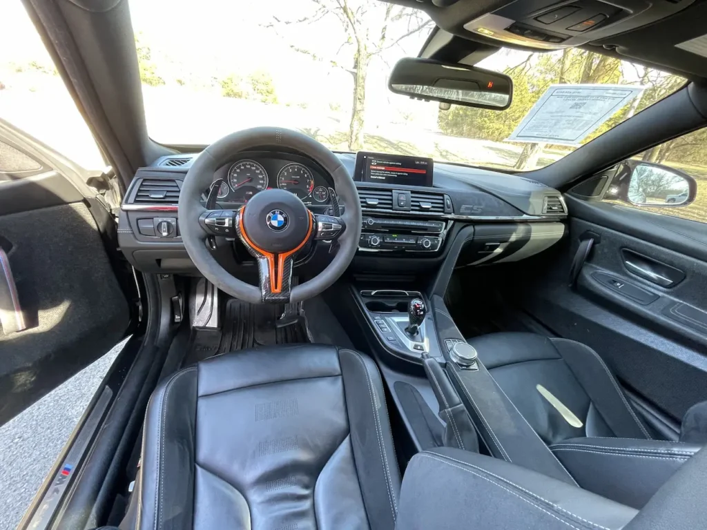 Full cabin view of 2019 BMW M4 CS showing steering wheel, infotainment, and center console layout.