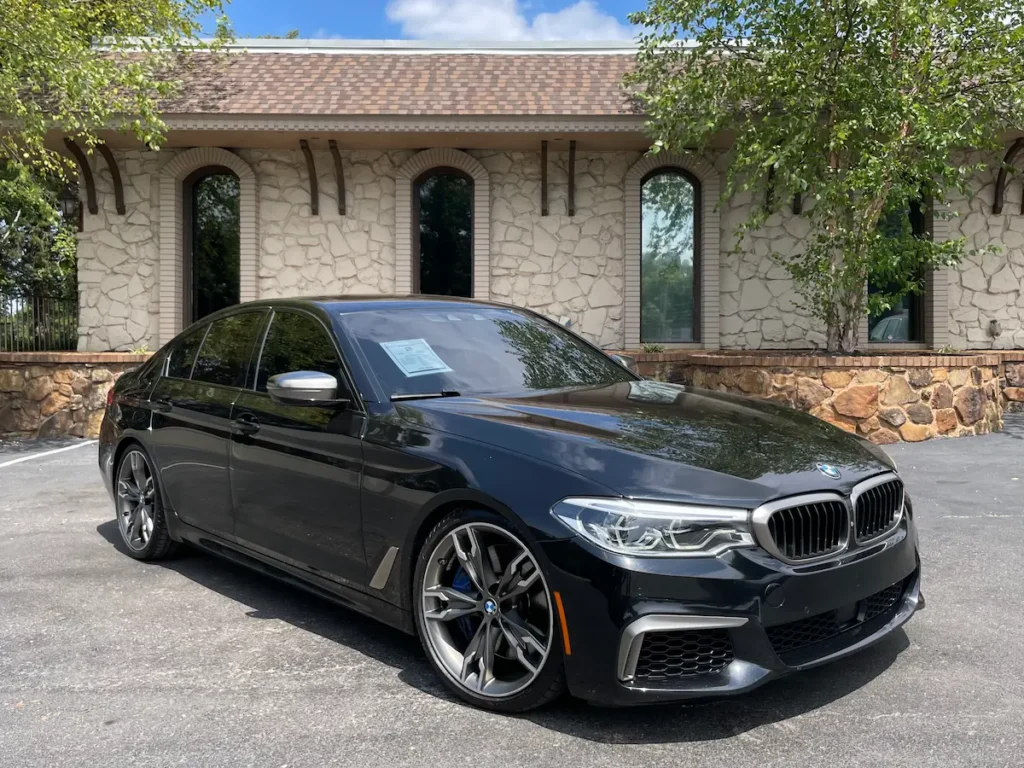 BMW M550i xDrive exterior front angle showing aggressive styling and sport sedan design.