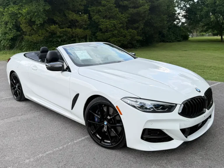 white BMW M850i convertible with black wheels parked outdoors, top down
