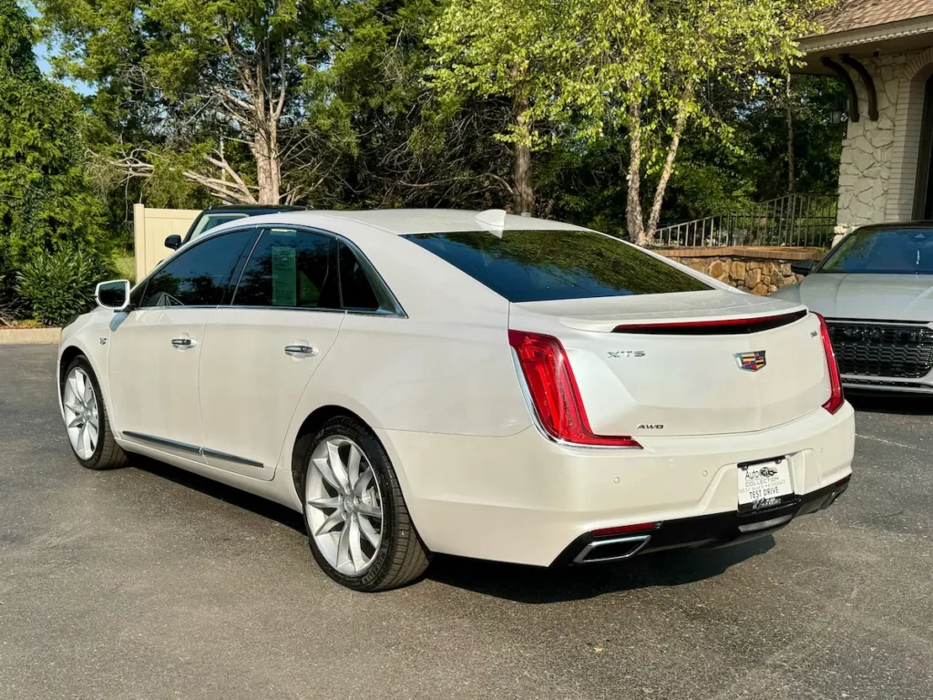 Rear exterior angle of a white 2019 Cadillac XTS AWD showcasing taillights and sleek body design.