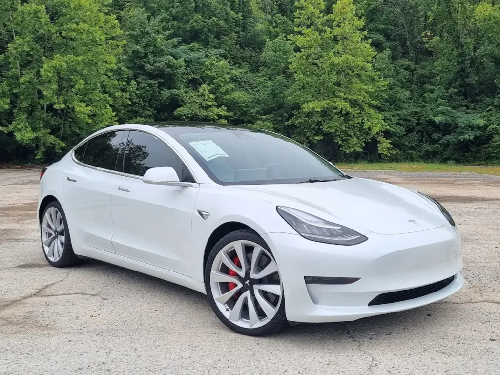 White 2019 Tesla Model 3 Performance seen from front three-quarter angle with aerodynamic body and LED headlights.