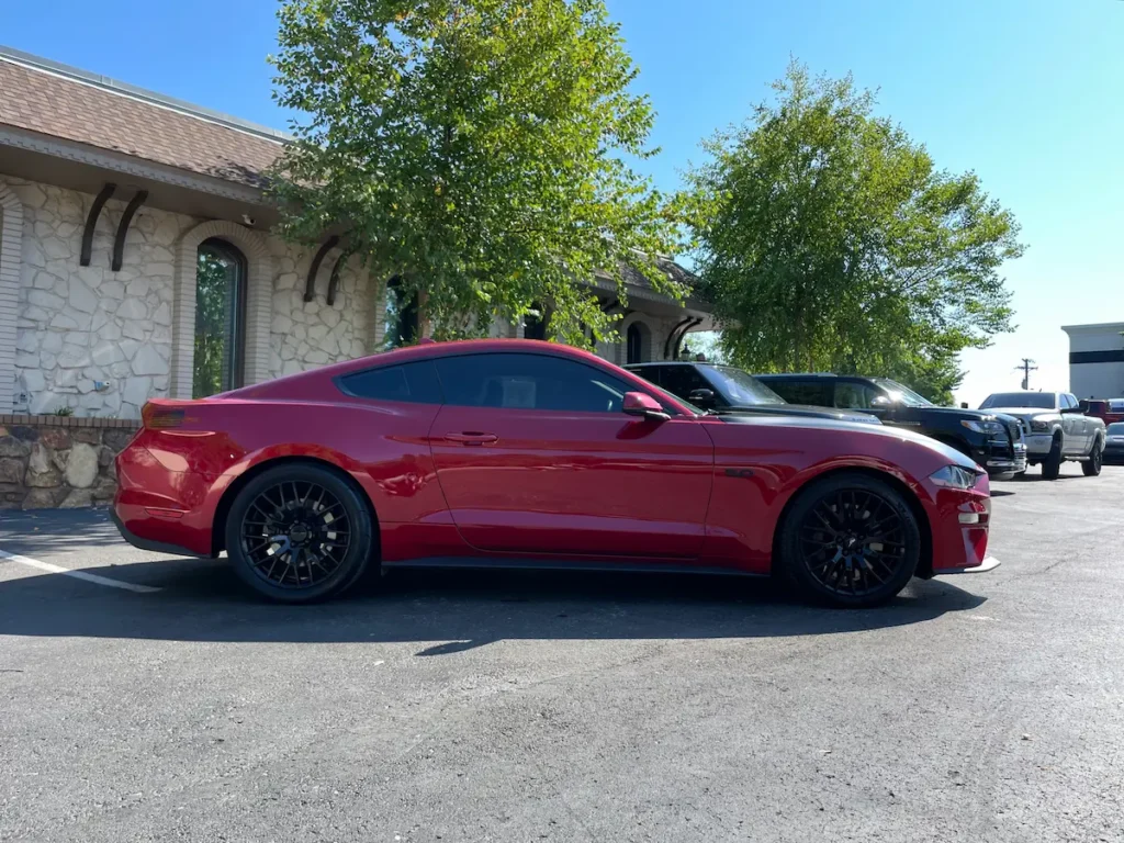 Side profile of a 2020 Ford Mustang GT in red with black wheels.