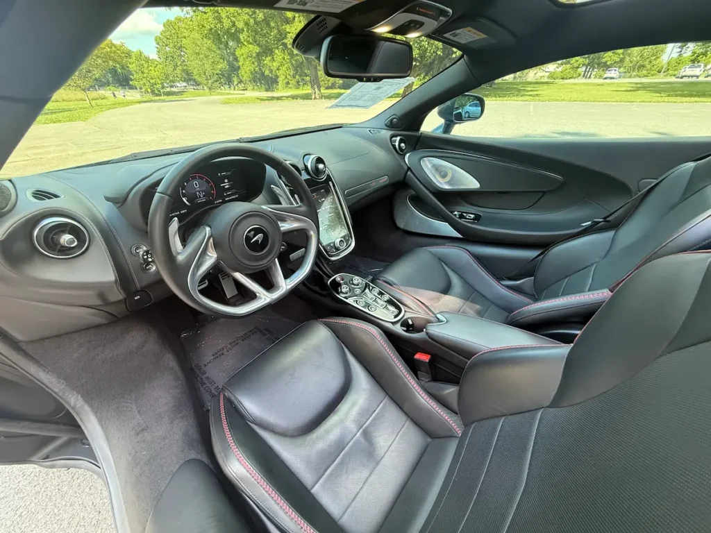 Interior of a 2020 McLaren GT showing the leather sport seats, digital driver display, and central infotainment console.