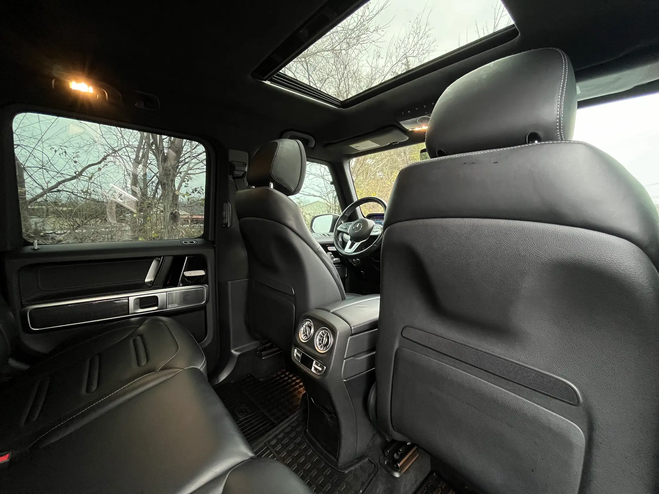 2020 Mercedes-Benz G 550 cabin viewed from the rear, showing black leather upholstery, rear air vents and sunroof.