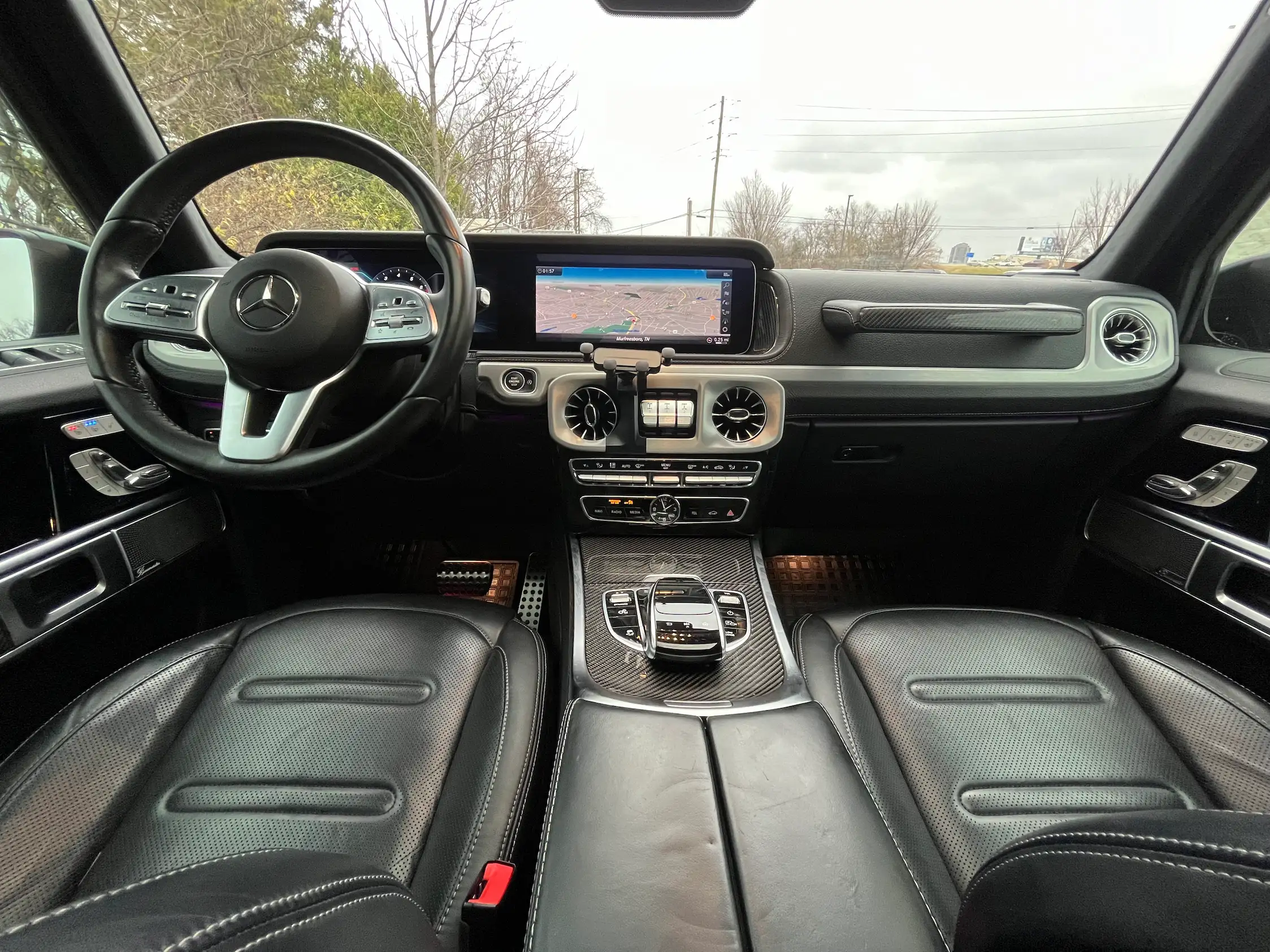 2020 Mercedes-Benz G 550 front cabin with black leather seats, dashboard displays and circular air vents.