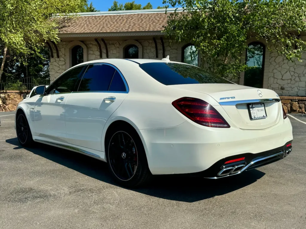 2020 Mercedes-Benz S63 AMG sedan in white showing rear design, quad exhausts, and sleek lines.