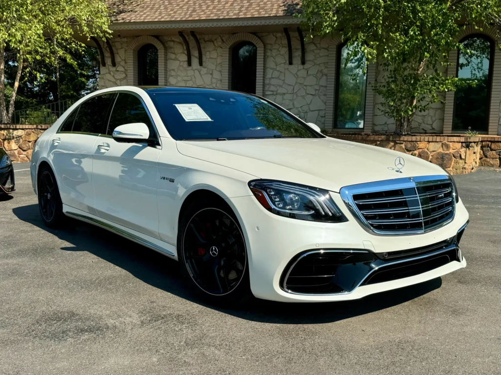 White Mercedes-AMG S63 Sedan, front-side view showcasing its luxury design and AMG styling.