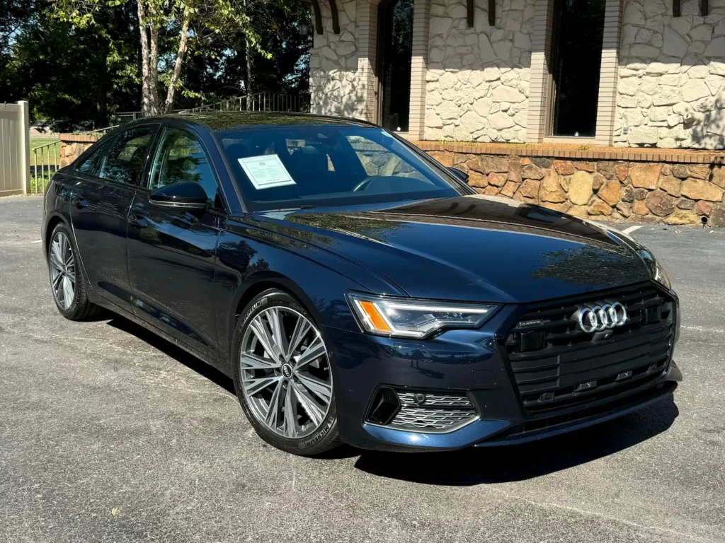 Front exterior view of the 2021 Audi A6 in blue, showcasing the signature Singleframe® grille, LED headlights, and sleek body design at AutoPro Nashville.