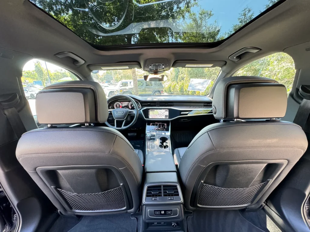 Rear interior view of the 2021 Audi A6 with black leather seats, panoramic sunroof, and rear climate controls at AutoPro Nashville.