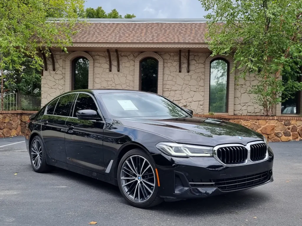 Black BMW 530i exterior front three-quarter view with kidney grille and alloy wheels.