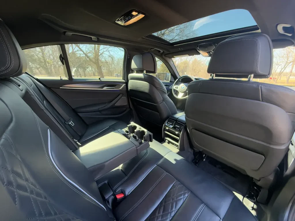 BMW 540i xDrive rear seat interior with quilted leather and luxury details.