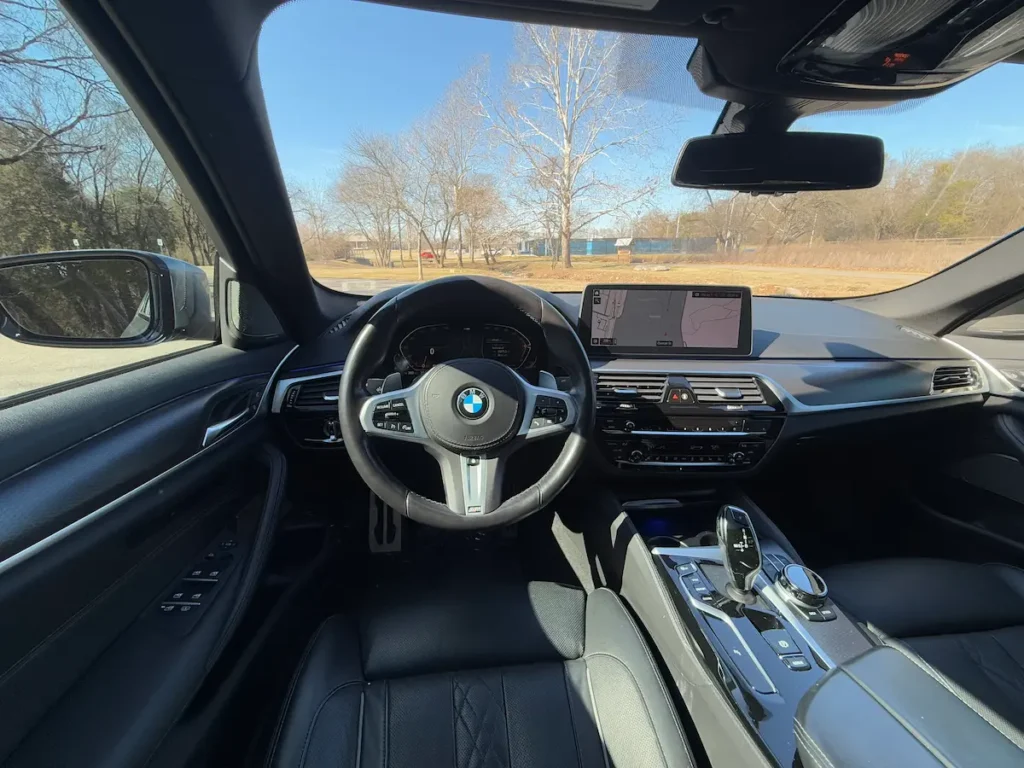 BMW 540i xDrive driver’s cockpit with M Sport steering wheel and digital display.