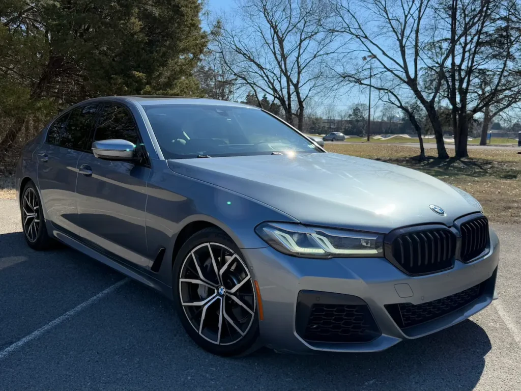 BMW 540i xDrive exterior front angle with M Sport body kit and LED headlights.