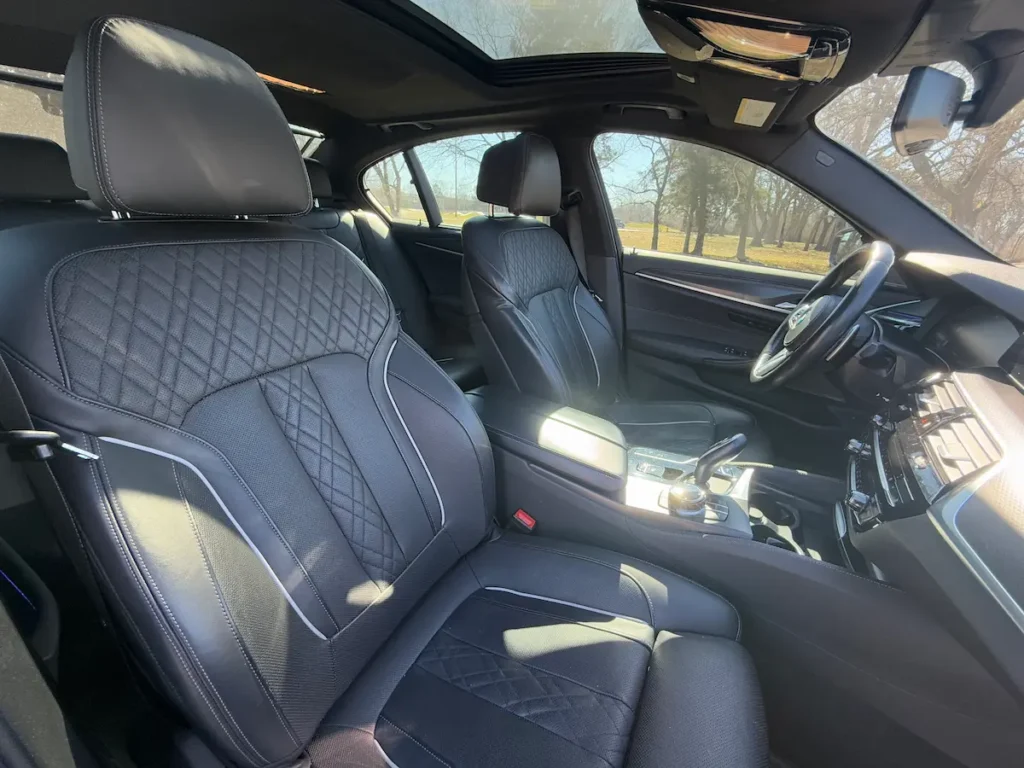 BMW 540i xDrive front seat interior with quilted leather and luxury seating package.