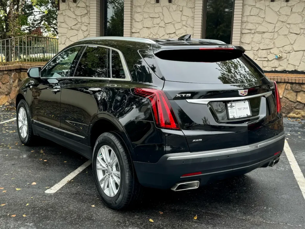 Rear exterior view of a black 2021 Cadillac XT5 AWD showing taillights, body lines, and rear design.
