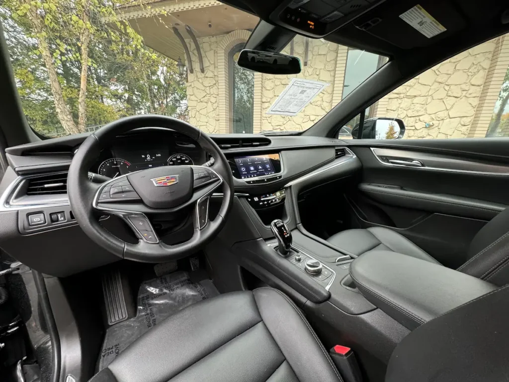 Interior view of a 2021 Cadillac XT5 showcasing the steering wheel, touchscreen display, and modern dashboard design.
