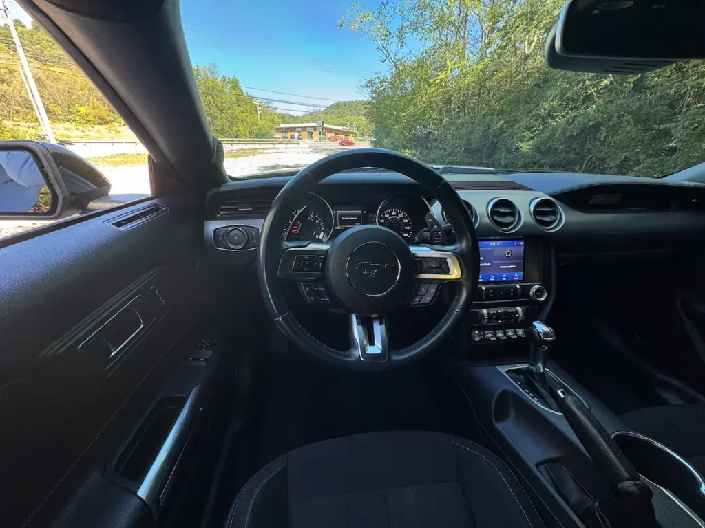 021 Ford Mustang interior featuring leather steering wheel, digital dash, and classic performance layout.