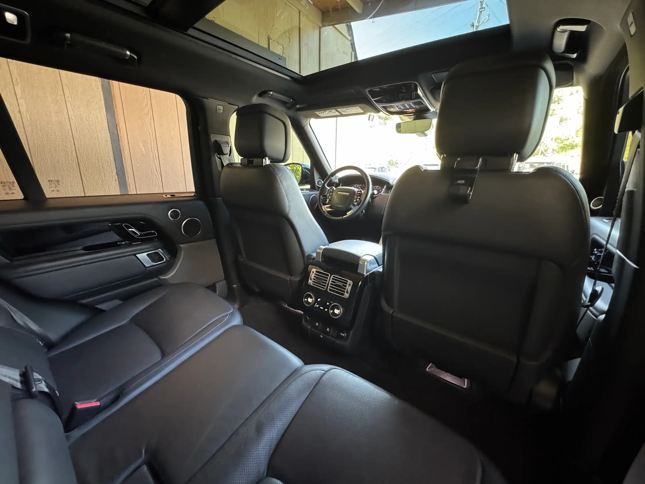 2021 Range Rover Westminster rear cabin with black leather seating, rear climate controls and a panoramic glass roof.