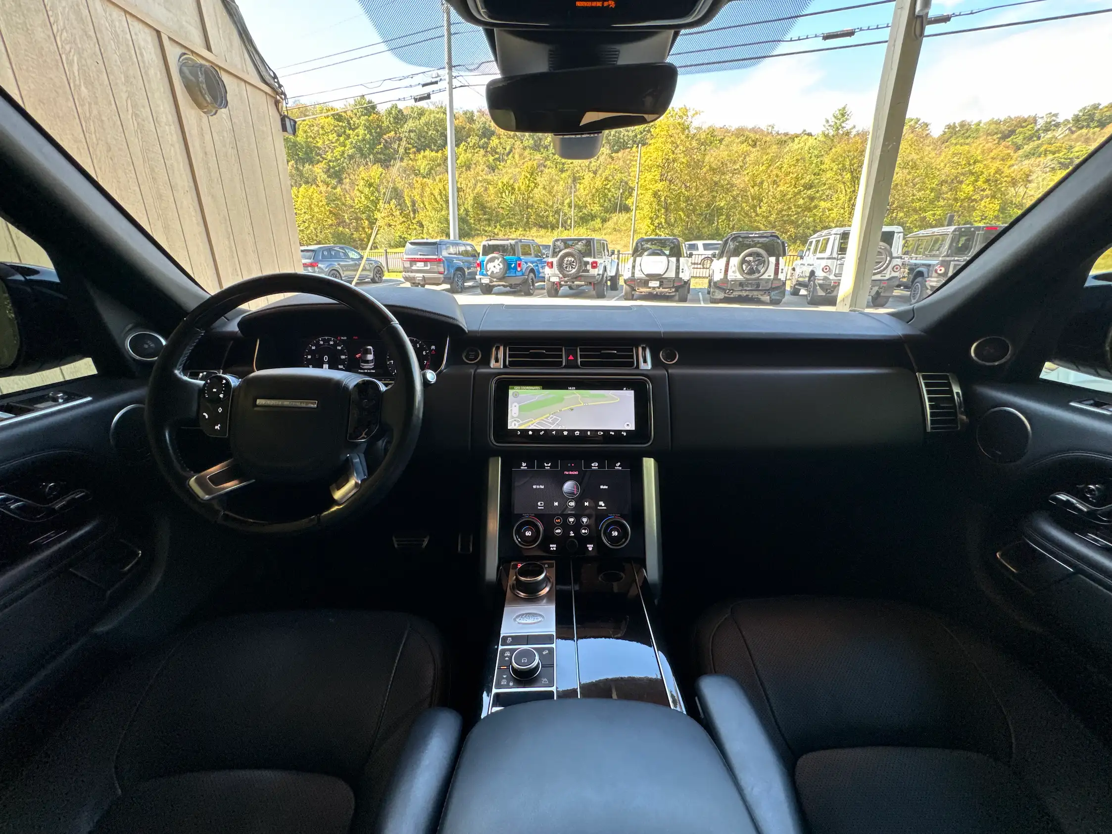2021 Range Rover Westminster dashboard with two center touchscreens, a black steering wheel and glossy center console.