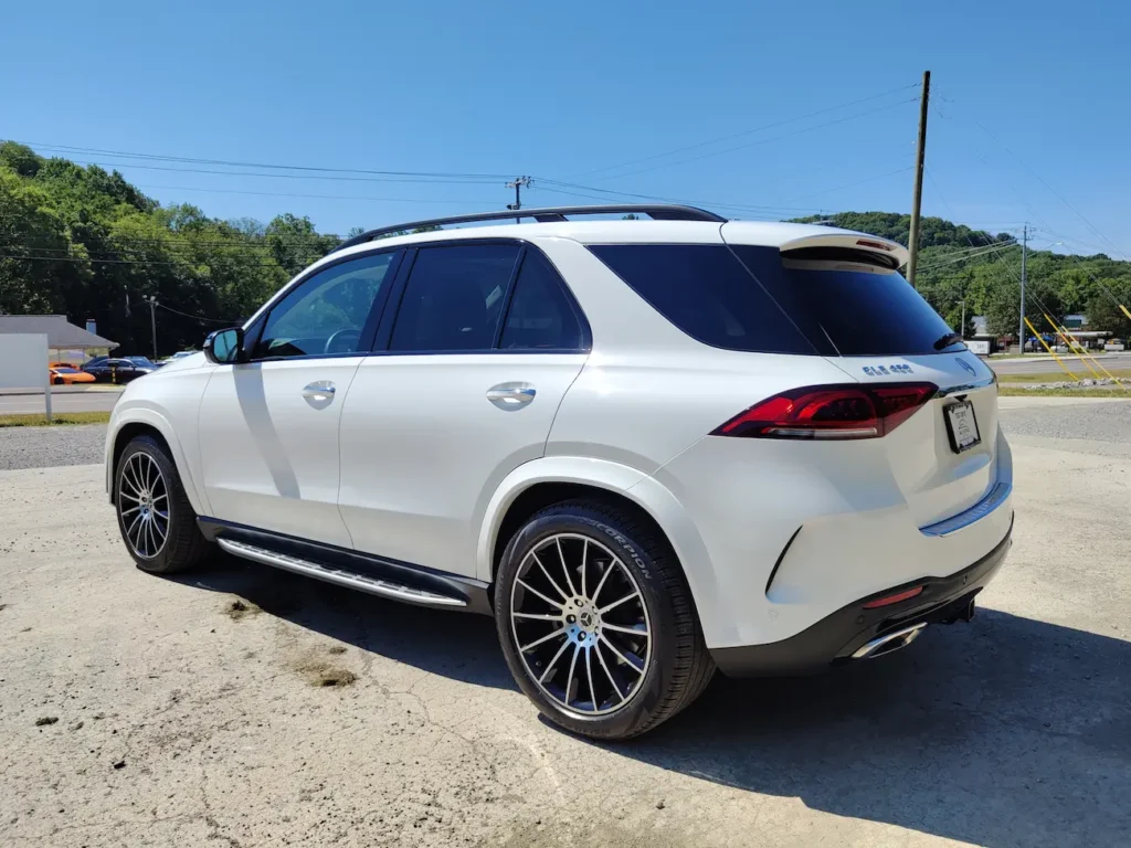 Side and rear angle of 2021 Mercedes-Benz GLE 450 in white showing tailgate and rear lights.