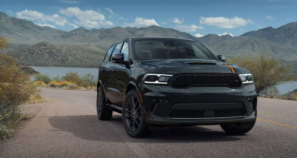 A black Dodge Durango parked outdoors with scenic mountains in the background.