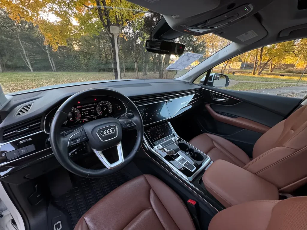 Interior of 2022 Audi Q7 featuring digital cockpit, dual touchscreens, and brown leather seats.
