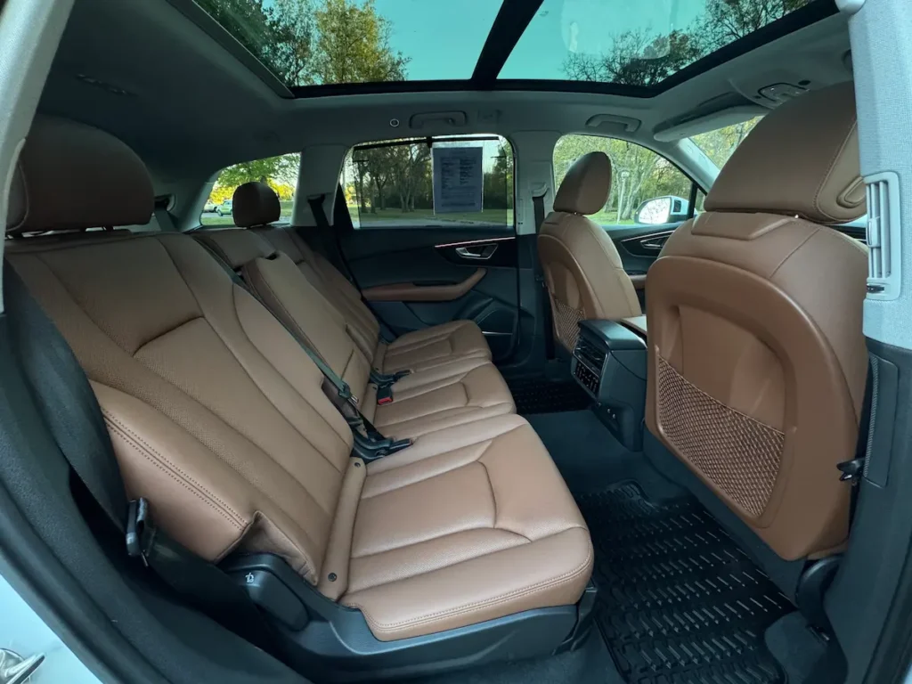 Rear seats of 2022 Audi Q7 with brown leather upholstery and panoramic sunroof.