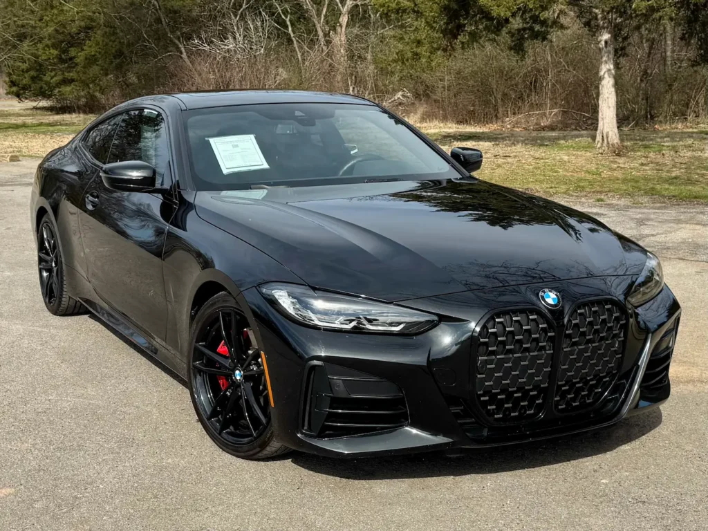 Sleek black 2022 BMW M440i Coupe with bold grille and red brake calipers.