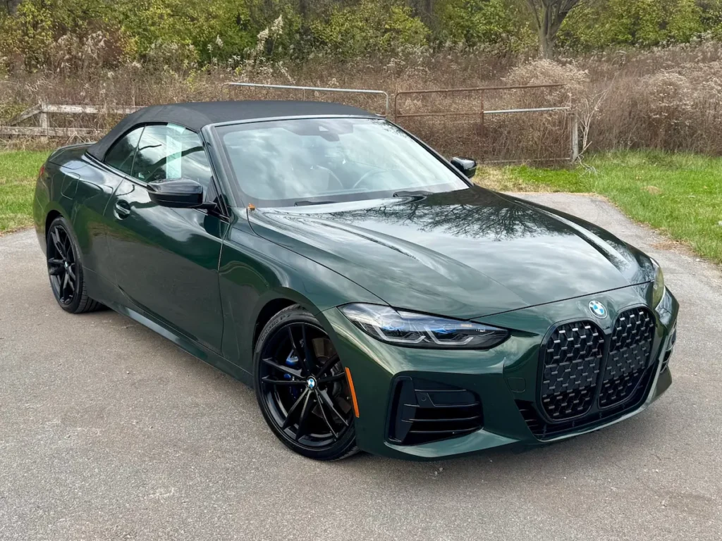 2022 BMW M440i Convertible in green with black wheels, front angle, premium performance design.