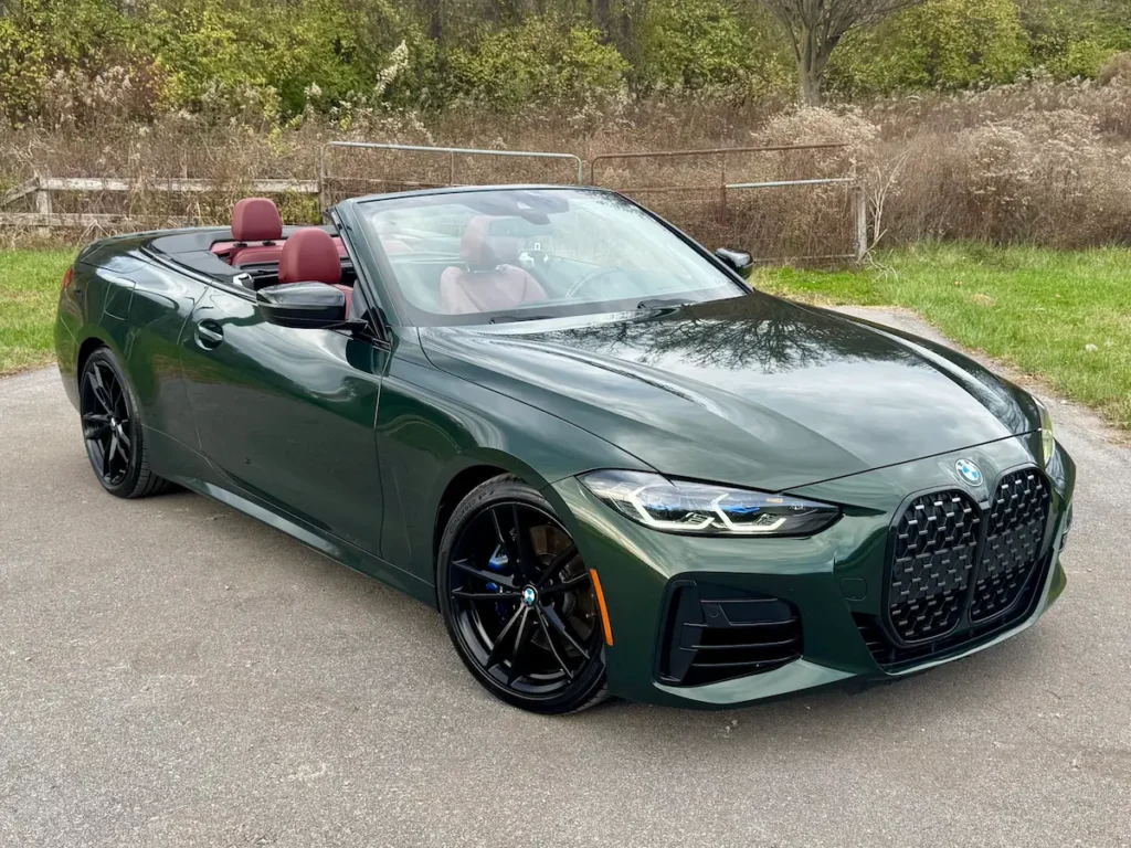 2022 BMW M440i Convertible green with top down, showcasing cabin and exterior styling.