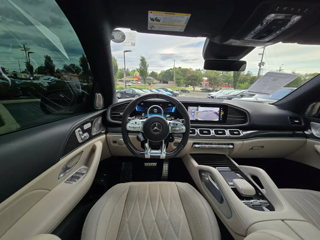 Interior view of the 2022 Mercedes-Benz GLS 63 AMG from the driver’s seat, showcasing the digital cockpit, AMG steering wheel, and premium leather finish.