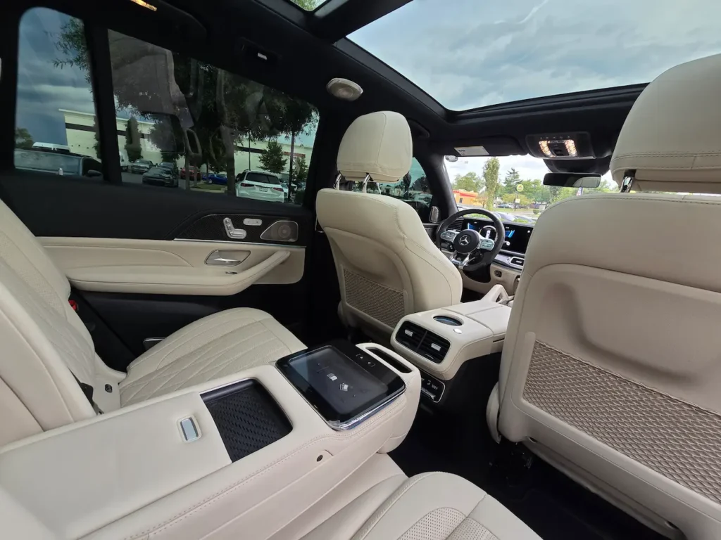 Rear interior of 2022 Mercedes-Benz GLS 63 AMG with quilted Nappa leather seats, rear climate controls, and panoramic sunroof.