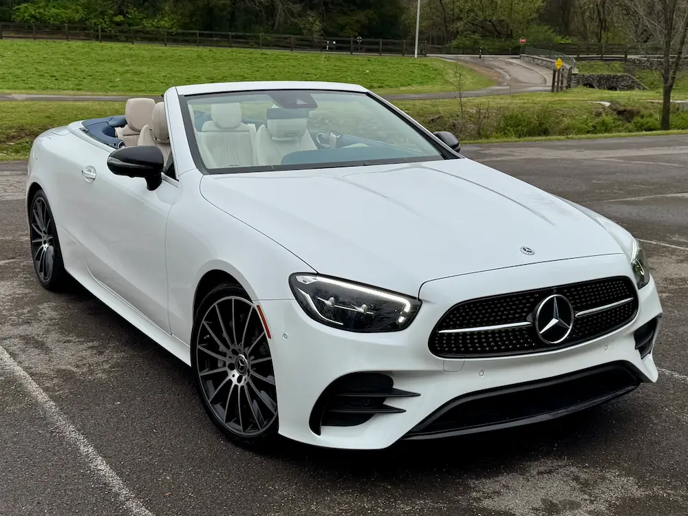 2022 Mercedes-Benz E 450 Cabriolet in white with AMG Line exterior and soft-top roof down.