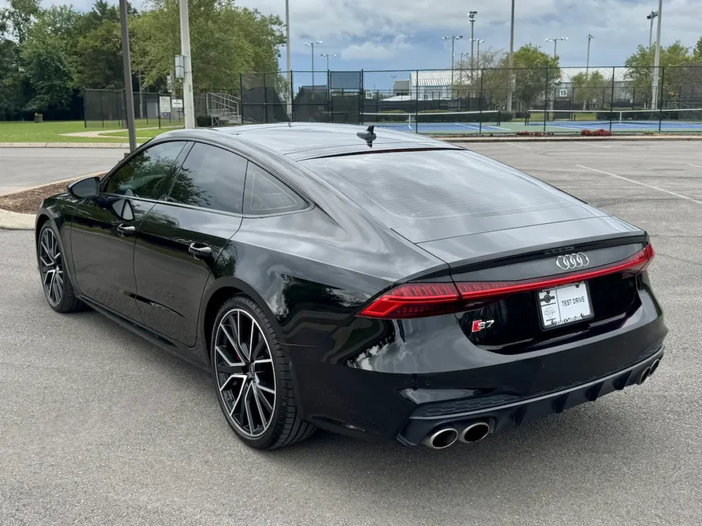 2023 Audi S7 in black viewed from rear angle showing quad exhaust tips and LED light bar.