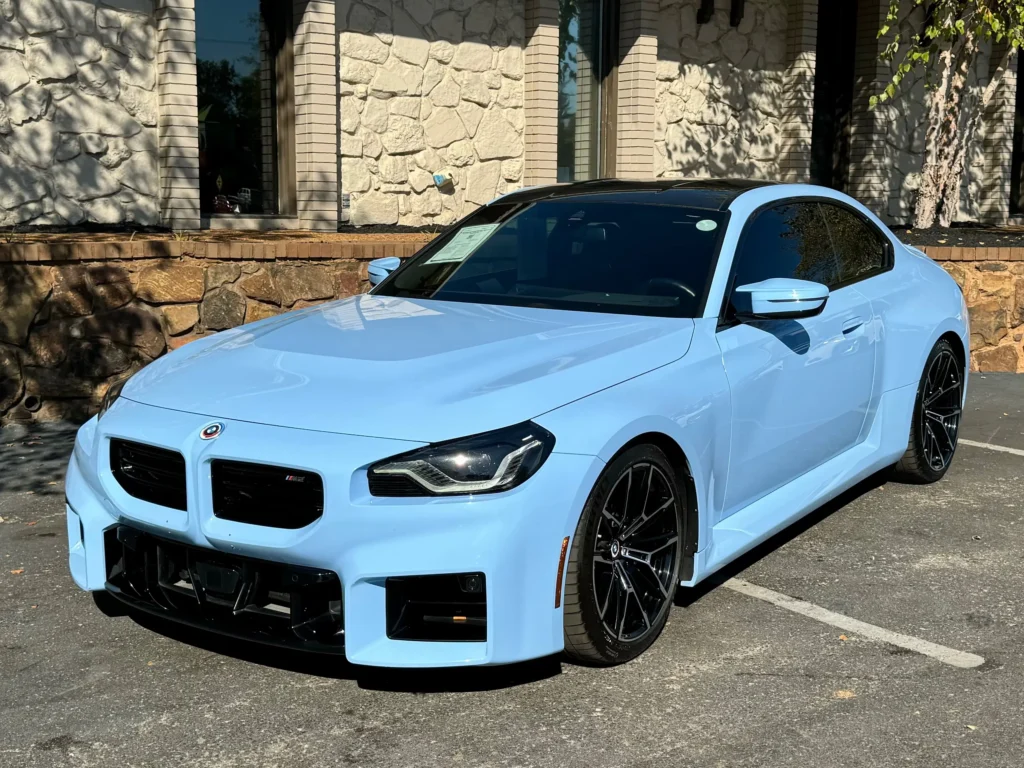 A 2023 BMW M2 in pastel blue parked at AutoPro Nashville.