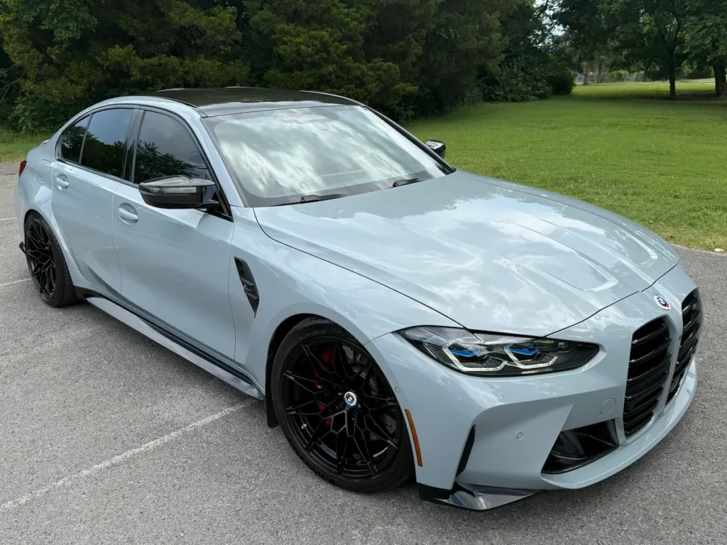 2023 BMW M3 grey exterior front three-quarter view with M-series styling and black wheels.