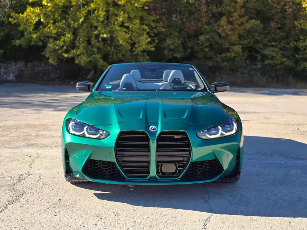 Front view of 2023 BMW M4 Competition Convertible in Isle of Man Green showing kidney grille and LED headlights.