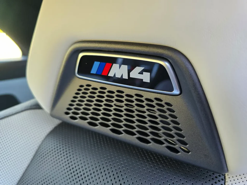Close-up of BMW M4 logo on integrated seat headrest of the 2023 M4 Competition Convertible.