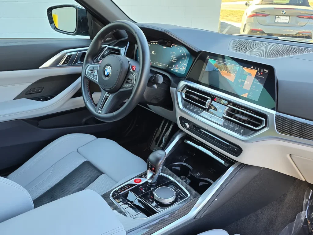 Dashboard and infotainment system of 2023 BMW M4 Competition Convertible showing M Drive controls and digital displays.