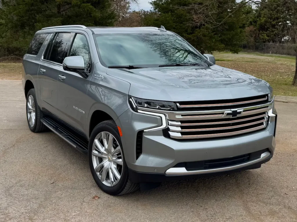 Front view of a 2023 Chevrolet Suburban High Country in silver with chrome grille and LED lights.