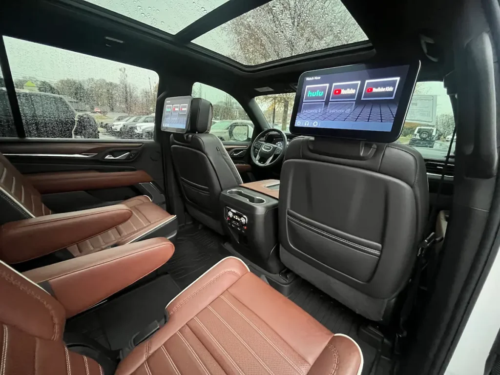 Rear-seat entertainment system and premium leather captain’s chairs inside a 2023 GMC Yukon XL Denali at AutoPro Nashville.