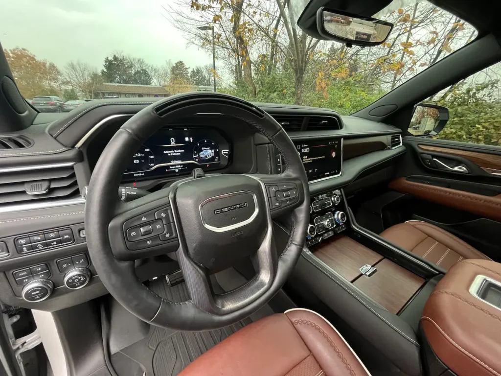 Driver cockpit of a 2023 GMC Yukon XL Denali with digital cluster and leather interior at AutoPro Nashville.
